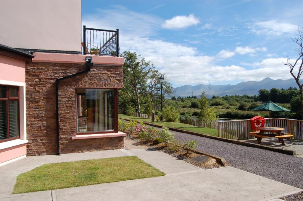 ein Backsteinhaus mit einer Terrasse und einem Picknicktisch in der Unterkunft Grove Lodge Holiday Homes in Killorglin