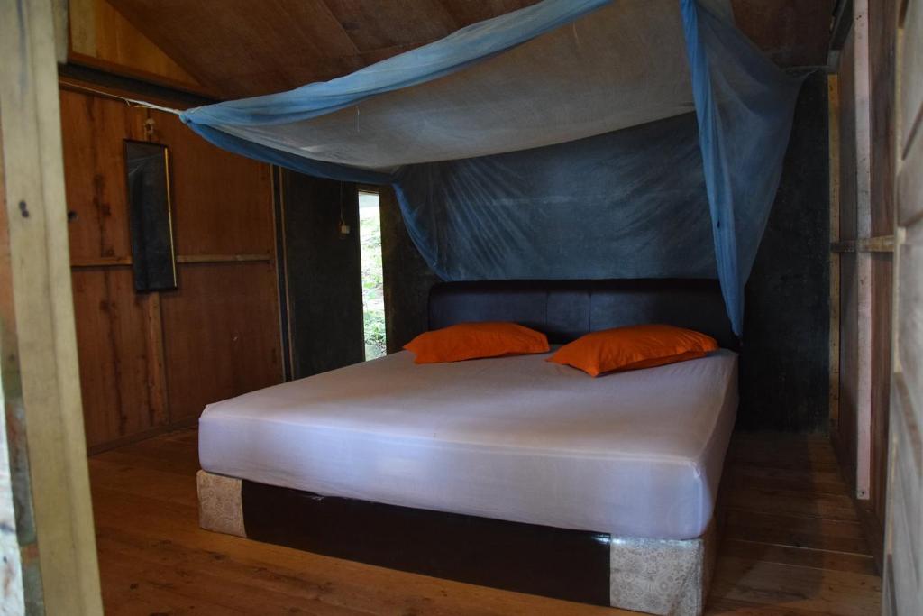 un letto in una camera con baldacchino di Olala Café & Bungalows a Sabang