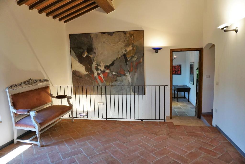 a living room with a chair and a painting on the wall at Casatorta in Vicchio