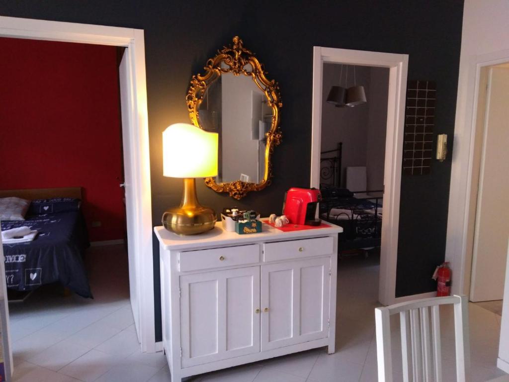 Zimmer mit einem weißen Schrank mit einer Lampe und einem Spiegel in der Unterkunft YourStay@Rome Vatican in Rom