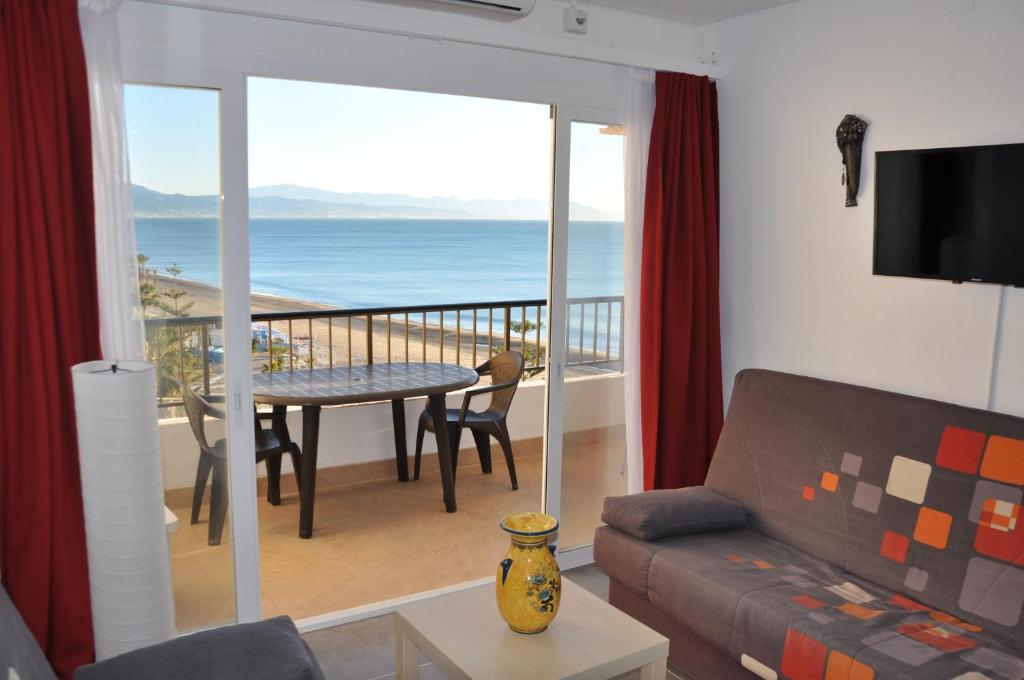 a living room with a couch and a balcony with the ocean at Appartement Vue Mer in Torremolinos