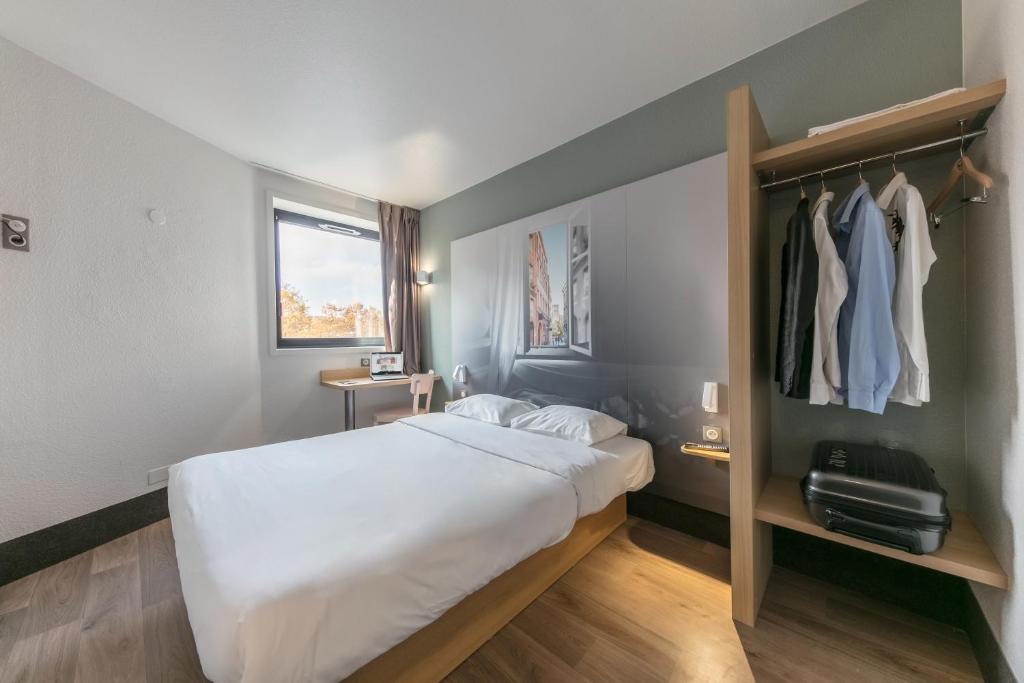 a bedroom with a large bed and a closet at B&B HOTEL Toulouse Centre Canal du Midi in Toulouse