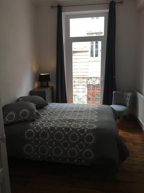 Un dormitorio con una cama y una ventana grande. en JLGR3, en Belfort