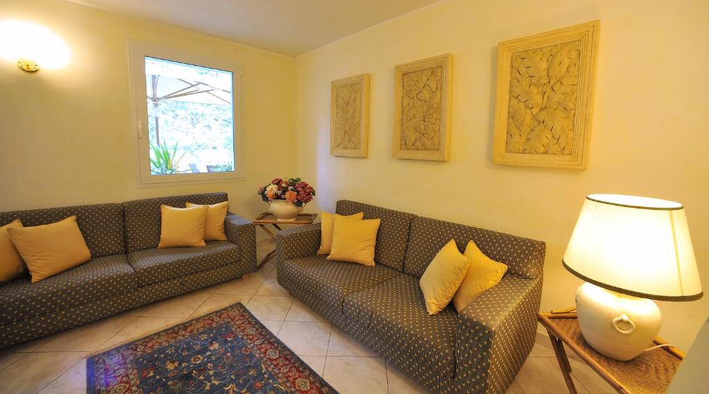a living room with two couches and a lamp at Hotel Riviera Blu in Tirrenia