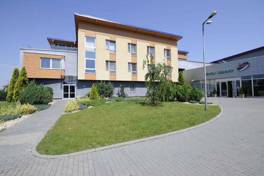 a building with a lawn in front of a building at Buly Aréna in Kravaře