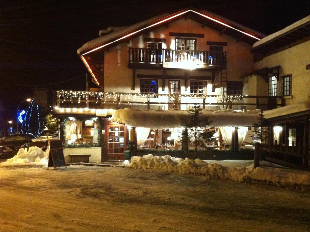 un edificio con luces de Navidad en la nieve por la noche en Hotel Franz en Allos