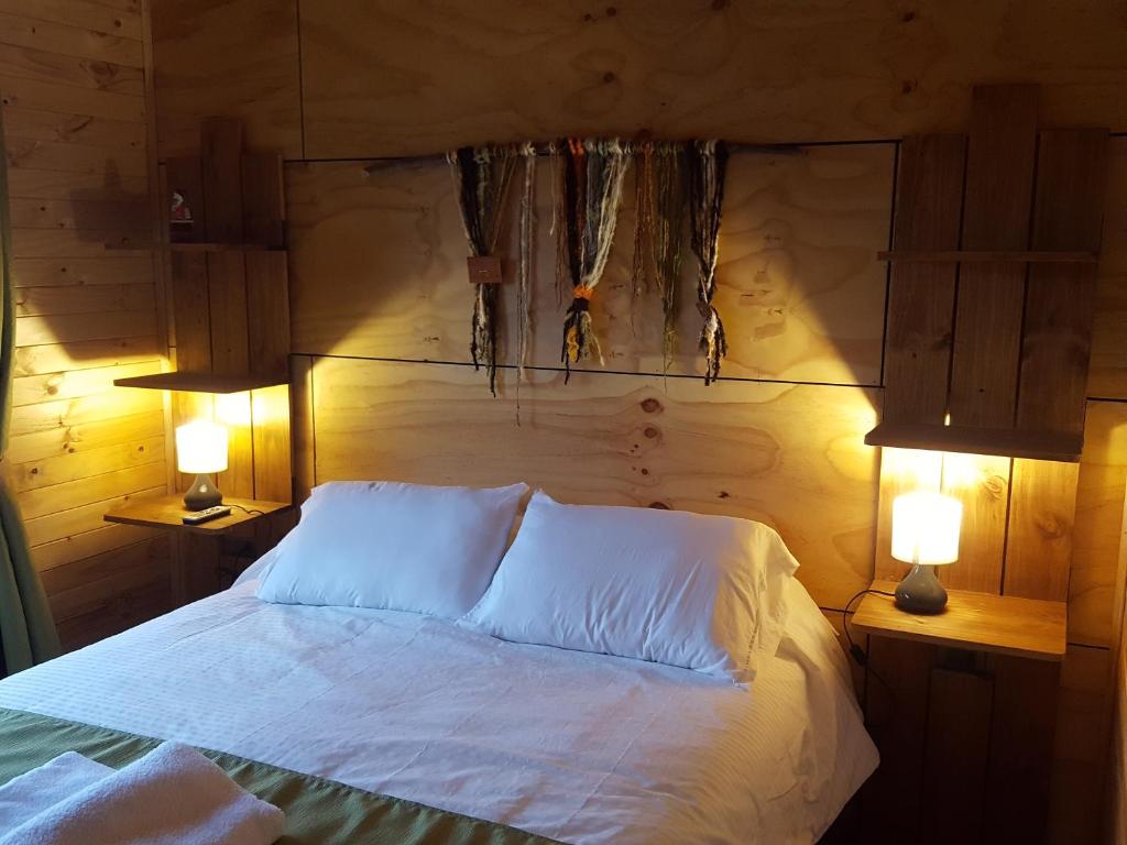 a bedroom with a white bed with two lamps at Hotel y Cabañas Terrazas Vista al Mar hct in Ancud
