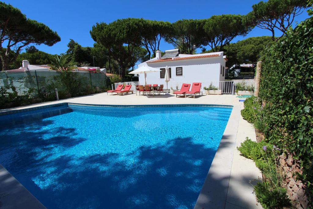 a swimming pool in front of a house at Villa Violeta 51 - Clever Details in Vilamoura
