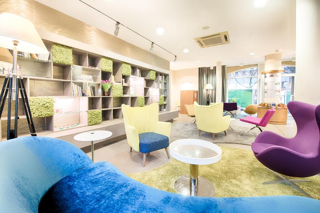 a living room with a blue couch and chairs at Hapimag Ferienwohnungen Berlin Zoo in Berlin