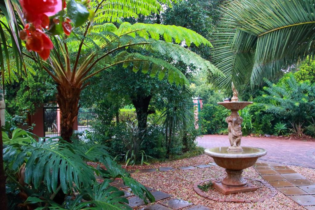 a fountain in the middle of a garden at Rozendal Guest House in Centurion