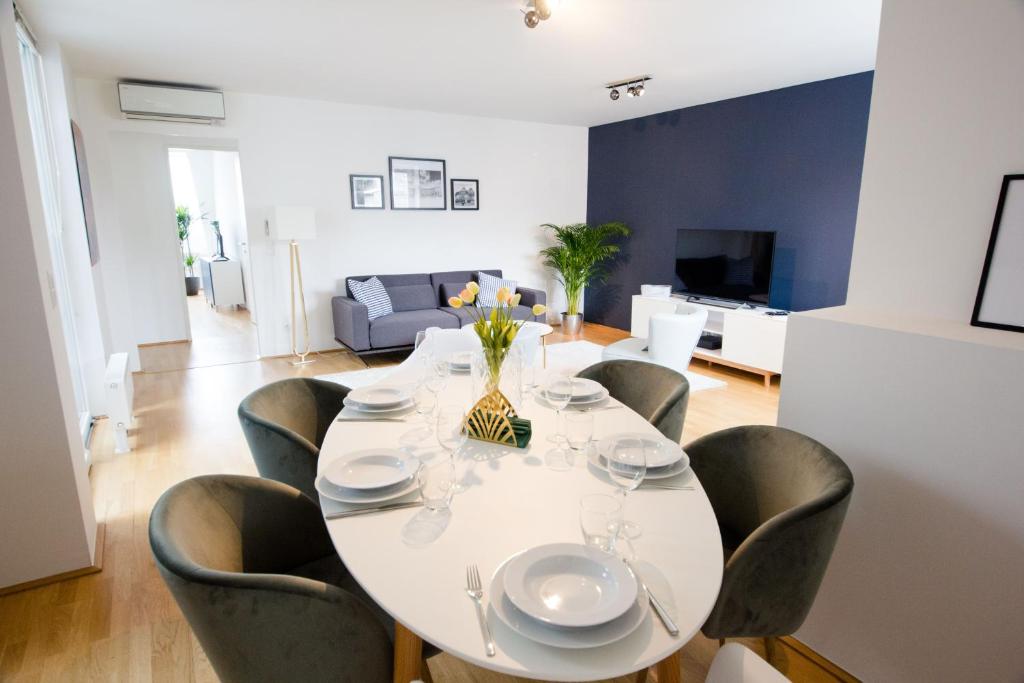 a dining room with a white table and chairs at Studio Apartments Naschmarkt - Mai's Apartments - Naschmarkt by Arbio in Vienna