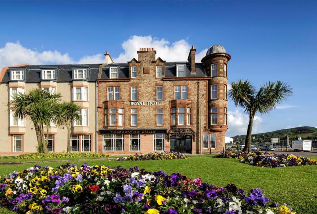 um grande edifício de tijolos com flores em frente em The Royal Hotel Campbeltown em Campbeltown