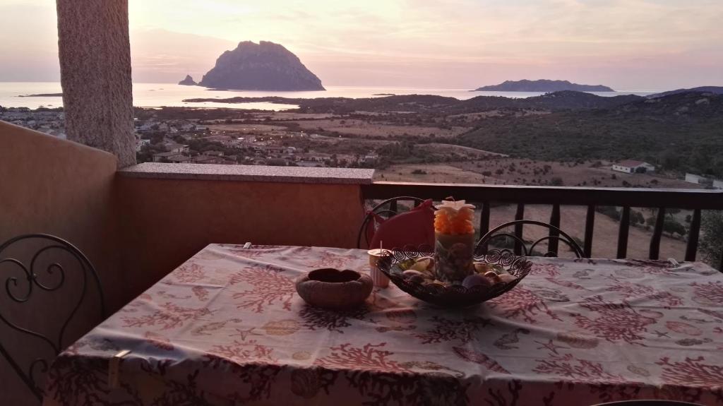 a table on a balcony with a view of the ocean at Appartamenti Sardegna in Porto San Paolo
