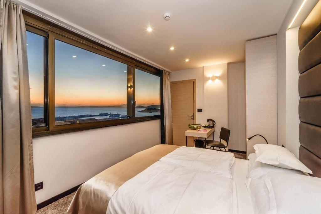 een slaapkamer met een bed en een groot raam bij The View Luxury Rooms in Split