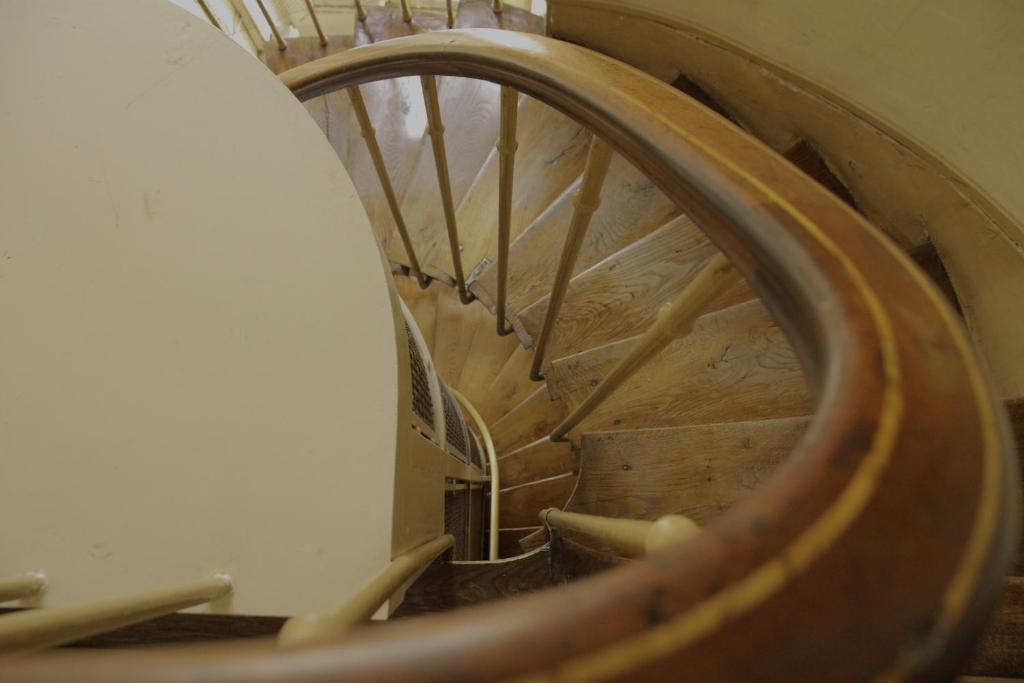 パリにあるスタジオ ロマンチック エ ボエームの木製の手すり付きの建物内の螺旋階段