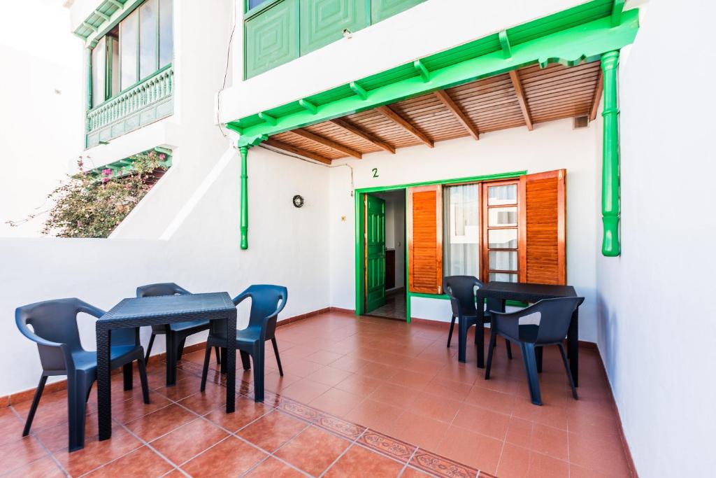 a patio with black tables and chairs on a white building at Vivienda Vacacional Playamar in Playa Honda