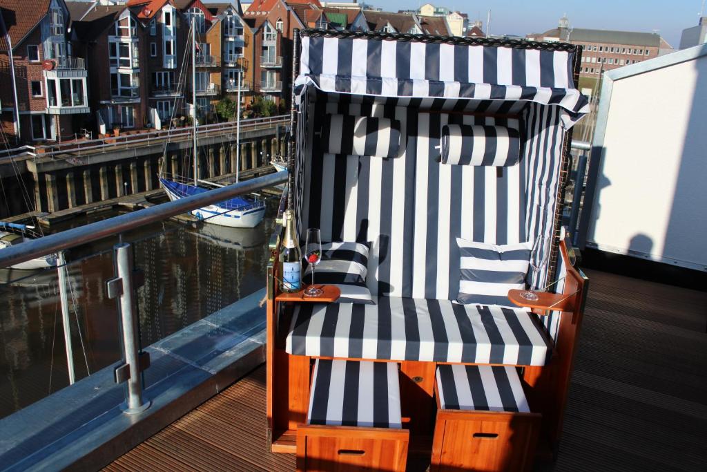 uma cadeira de baloiço sentada no convés de um barco em Ferienhaus Hafenzeit em Cuxhaven