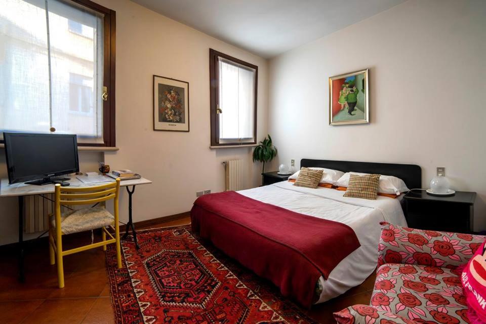 a bedroom with a bed and a desk with a computer at Holiday Treviso Suite LOMBARDI in Treviso