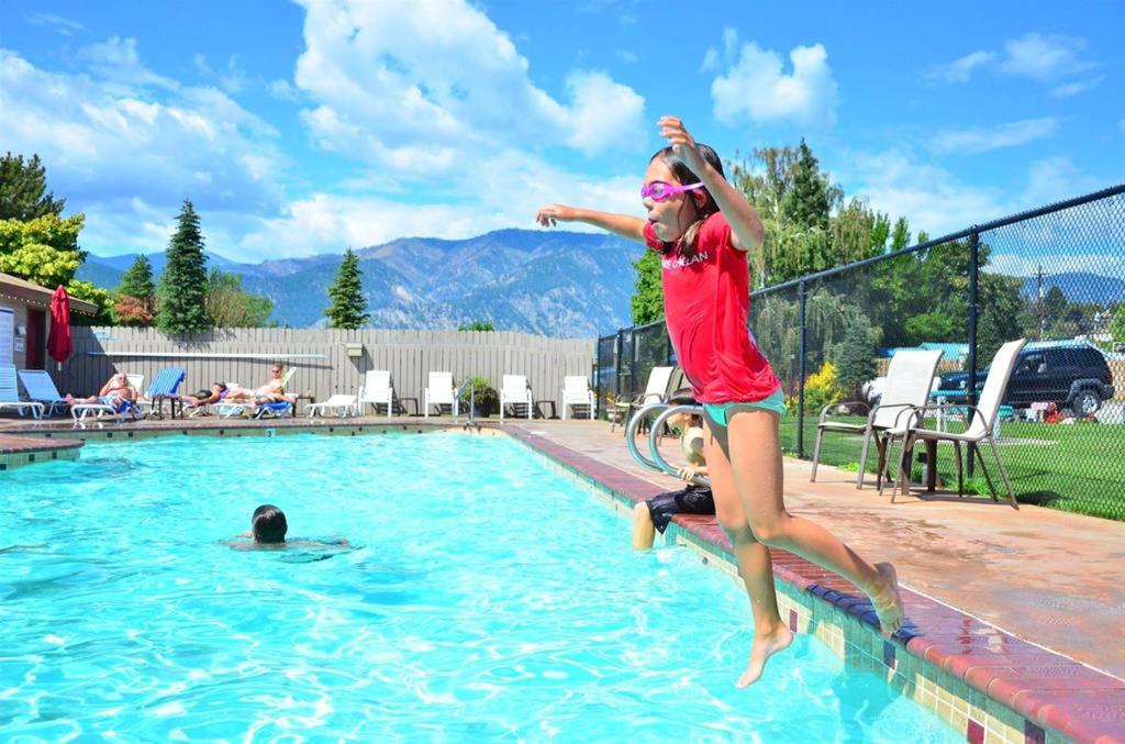 a woman jumping into a swimming pool at Mountain View Lodge in Chelan