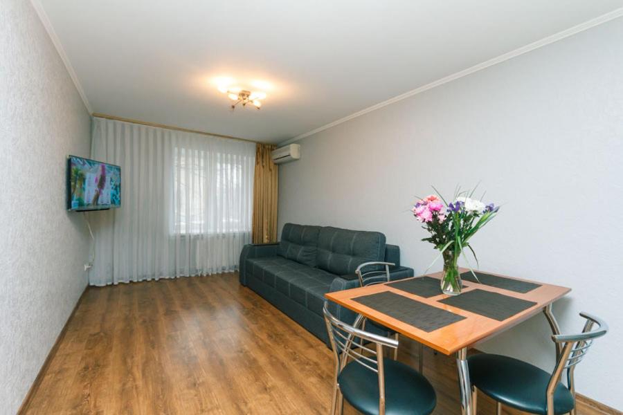 sala de estar con sofá y mesa con flores en Two bedsright near Arena, en Kiev