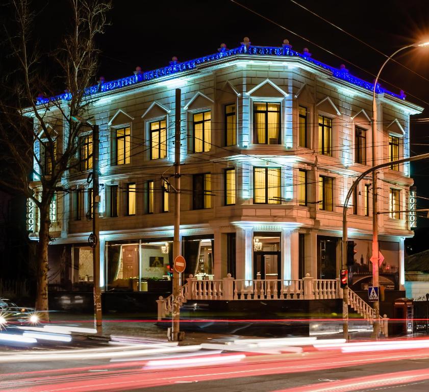 a lit up building on a city street at night at London Boutique Hotel in Chişinău