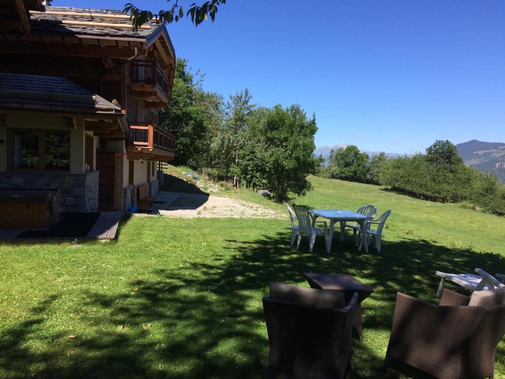 a table and chairs in a yard next to a house at Chalet Emilie in Courchevel