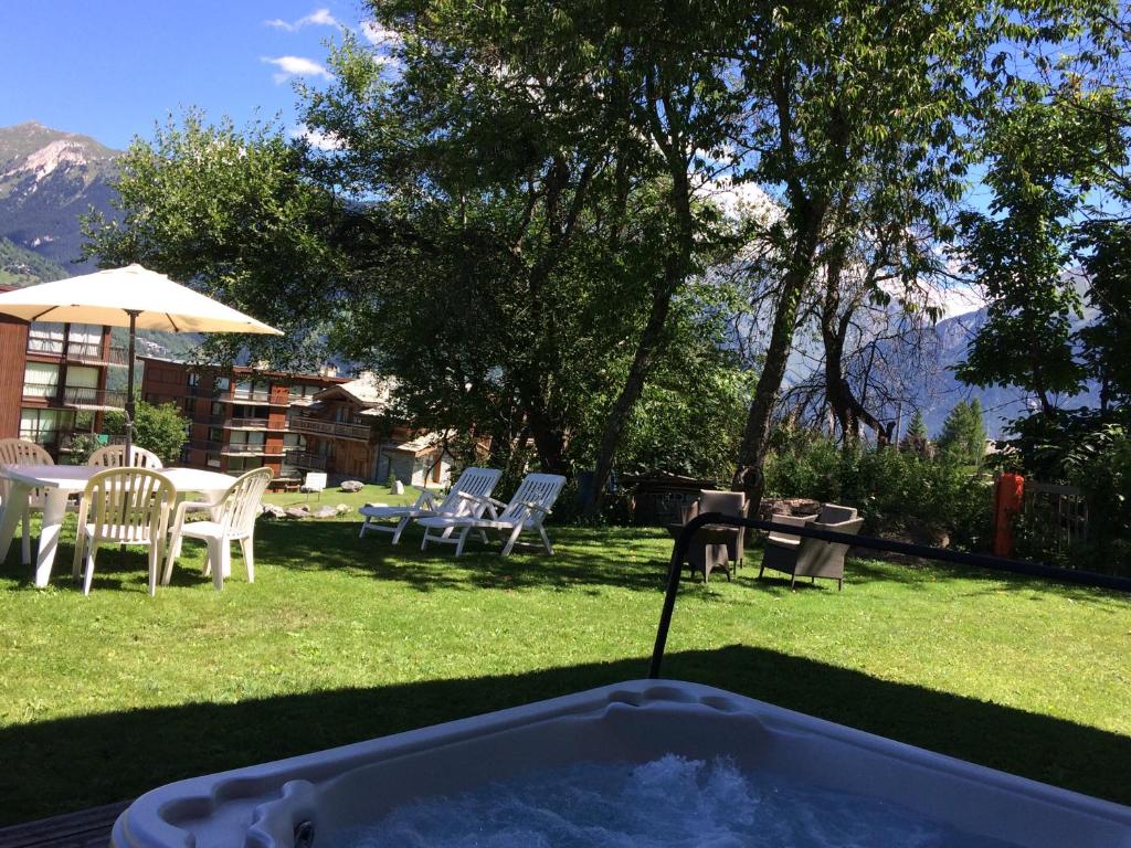 a hot tub in a yard with chairs and a table at Chalet Emilie in Courchevel