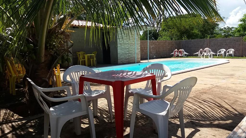 una mesa y sillas frente a una piscina en Hotel Pousada Lagoa Azul, en Paranaíba