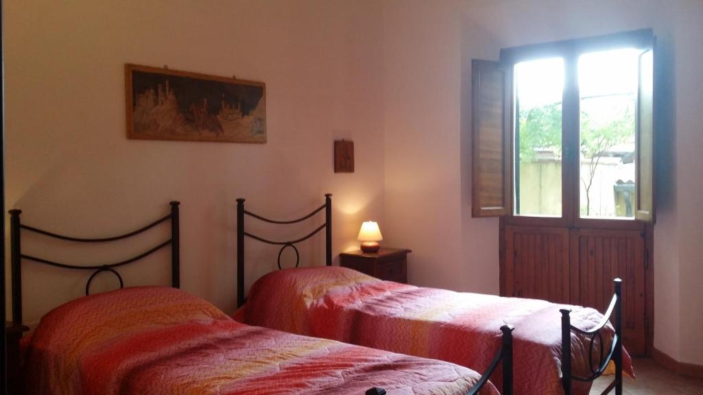 sypialnia z dwoma łóżkami i oknem w obiekcie Sunflower w mieście San Quirico dʼOrcia