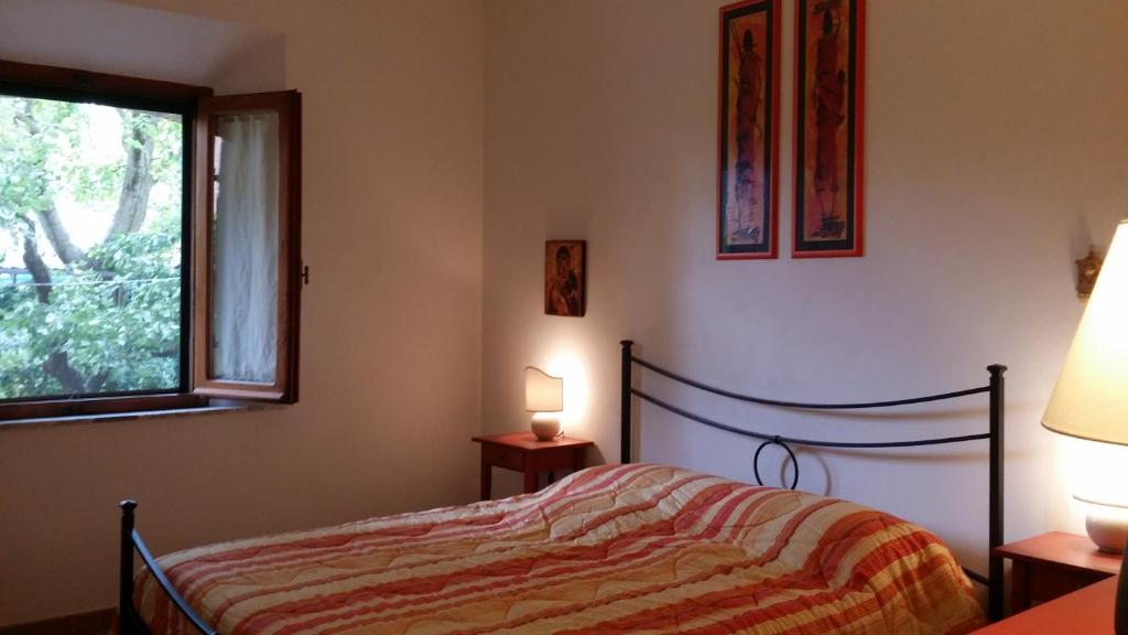 a bedroom with a bed and a window at Sunflower in San Quirico dʼOrcia