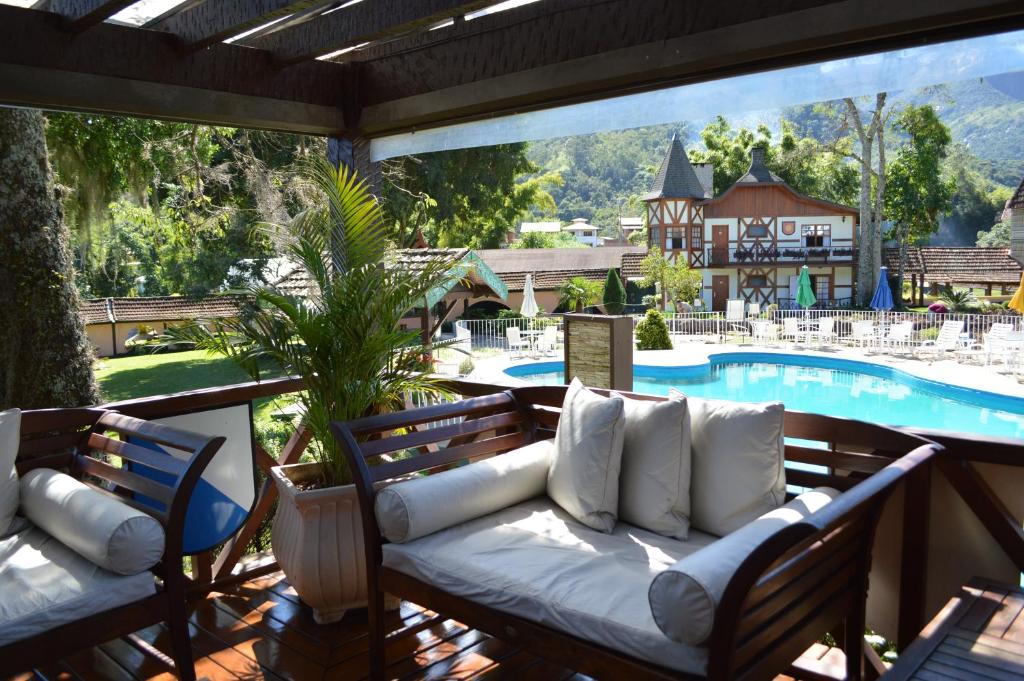 a living room filled with furniture and a pool at Village Le Canton in Teresópolis