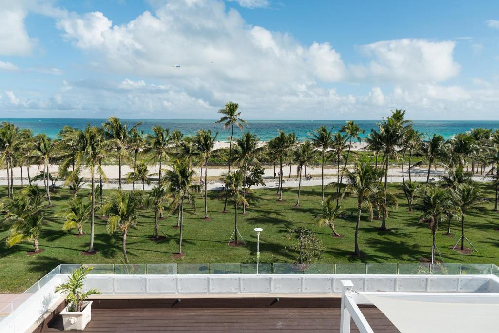 uma vista para a praia a partir da varanda de um resort em Penguin Hotel em Miami Beach
