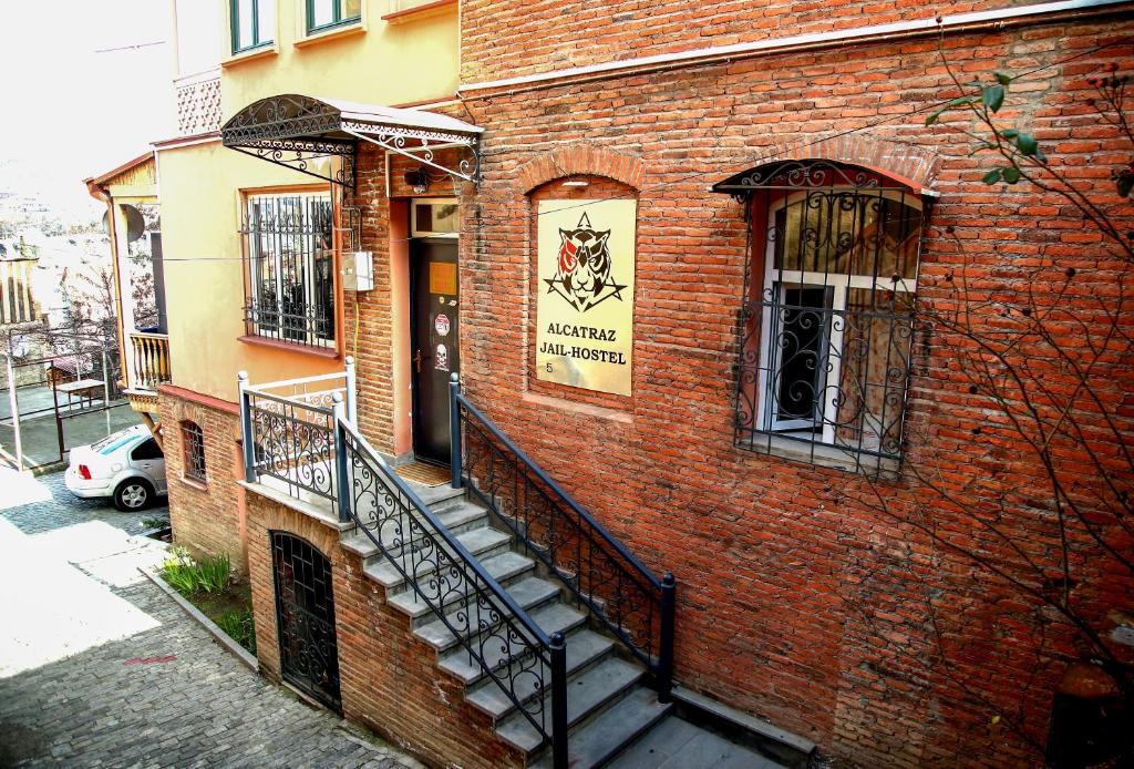 een bakstenen gebouw met trappen aan de zijkant bij ALCATRAZ JAIL-HOSTEL in Tbilisi City