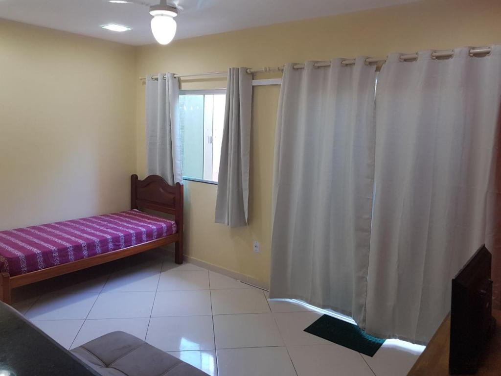 sala de estar con ventana y sofá púrpura en Brilho do Sol Hospedagem, en Arraial do Cabo