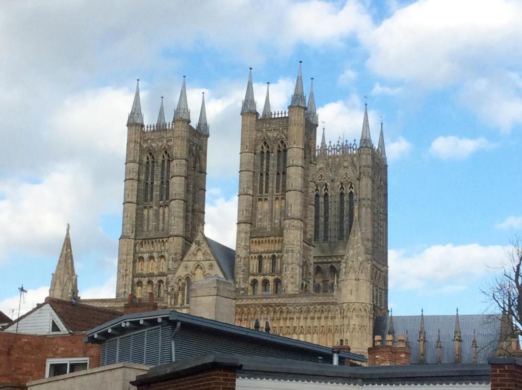 une grande cathédrale avec des tours au-dessus d'un bâtiment dans l'établissement Castle View Cottage, à Lincoln