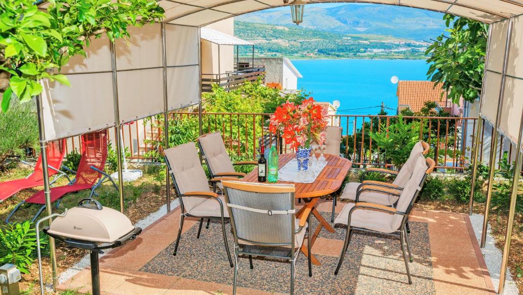 una mesa y sillas en un patio con vistas al agua en Apartments Mandaric, en Trogir