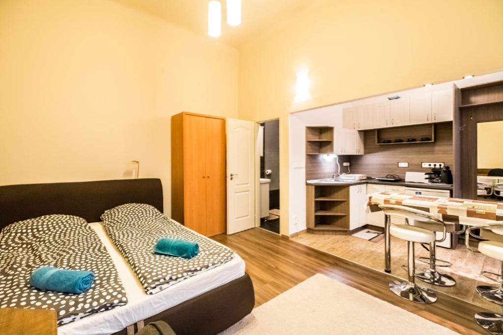 ブダペストにあるDombóvári way apartmanのリビングルーム(ベッド1台付)、キッチンが備わります。
