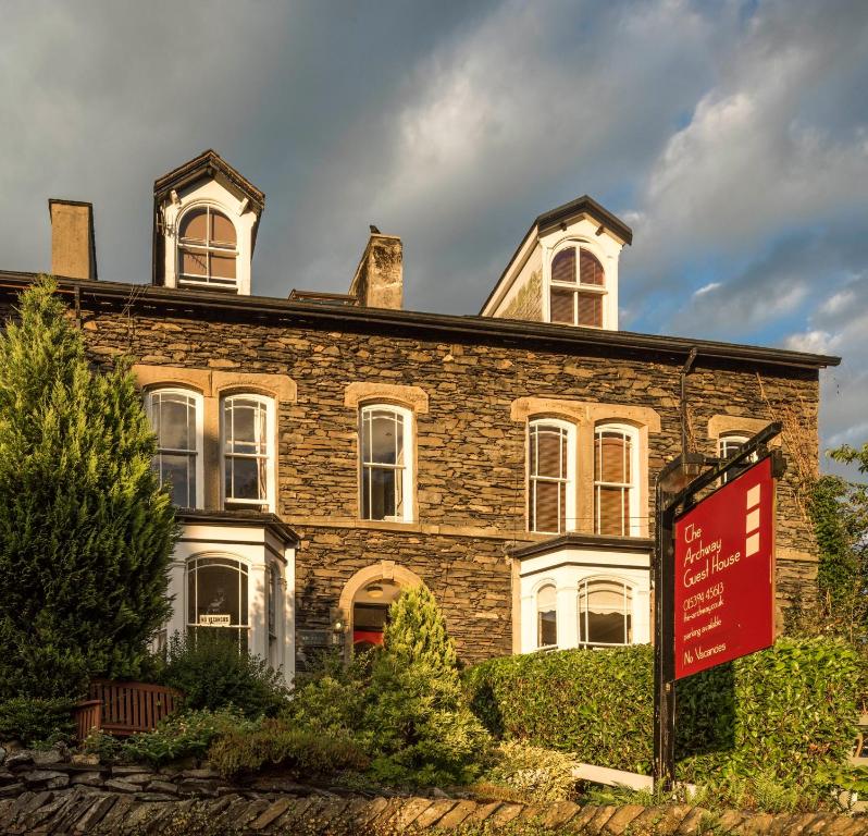 a large brick house with a sign in front of it at Archway Guest House in Windermere