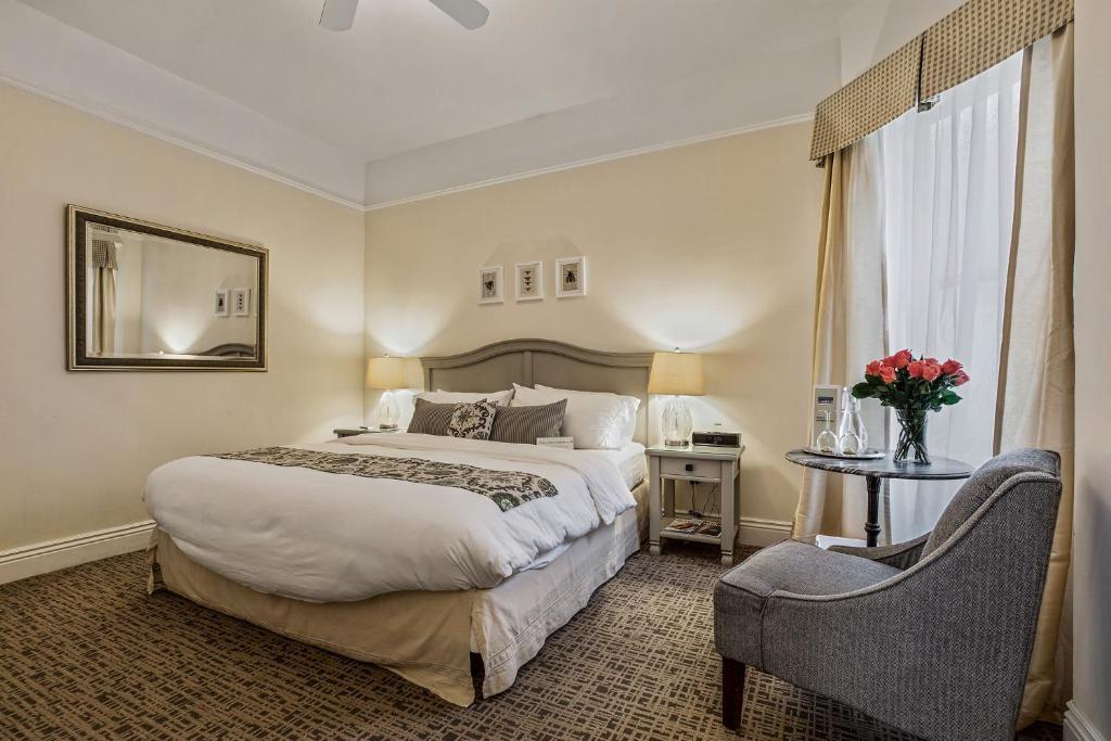 a hotel room with a large bed and a chair at Parker Guest House in San Francisco