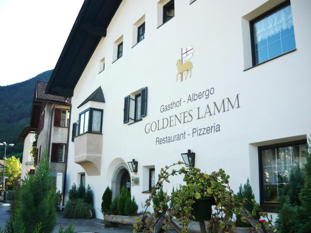 ein Gebäude mit einem Schild an der Seite in der Unterkunft Gasthof Goldenes Lamm in Brixen