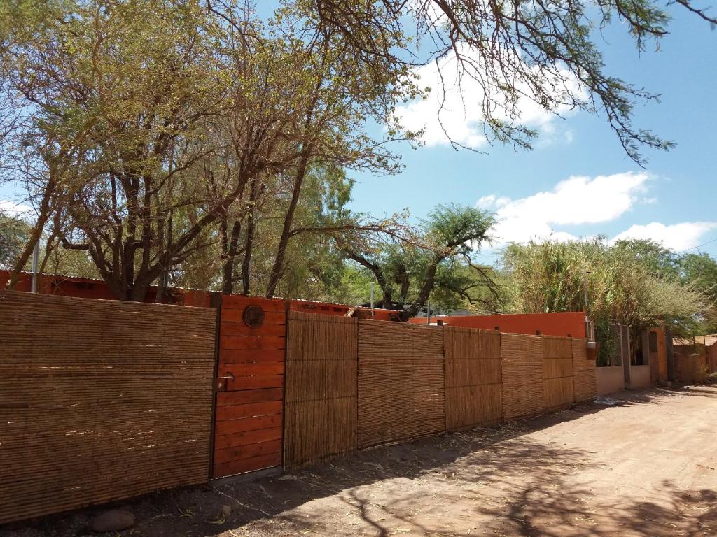 una valla de madera frente a un camino de tierra en Hostal Perita, en San Pedro de Atacama