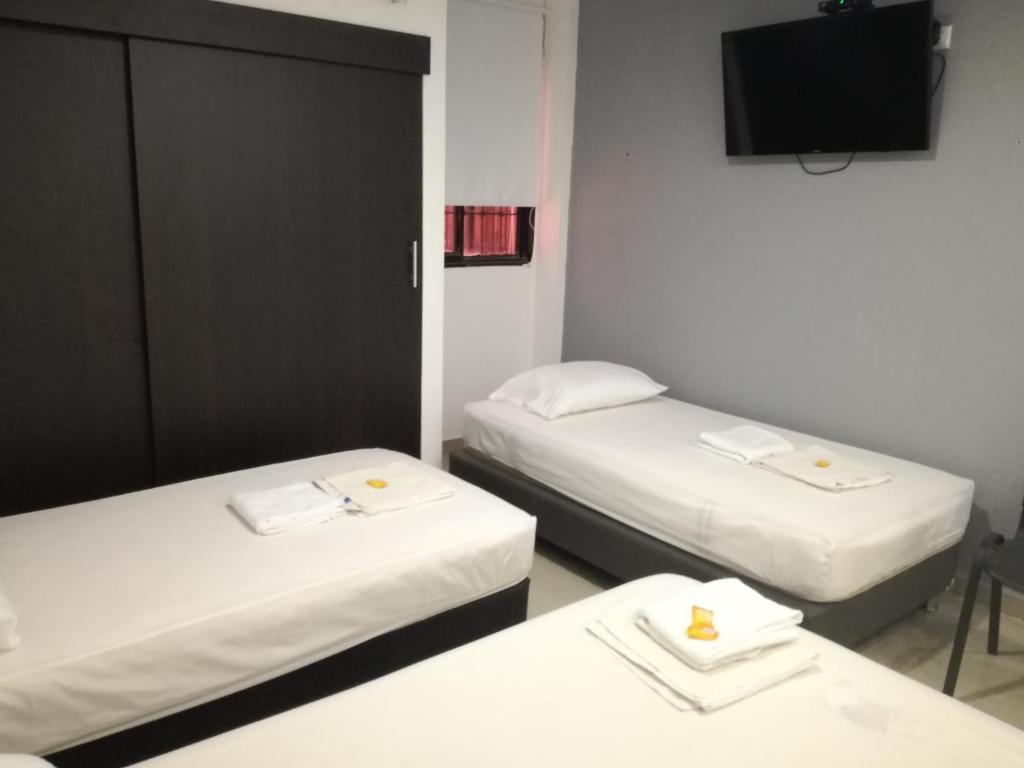 Postel nebo postele na pokoji v ubytování Aparta Hotel El Cacique Upar
