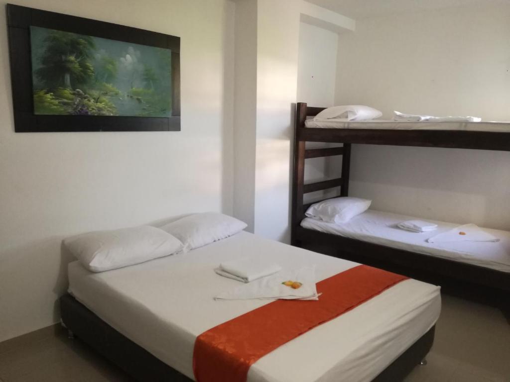 Postel nebo postele na pokoji v ubytování Aparta Hotel El Cacique Upar