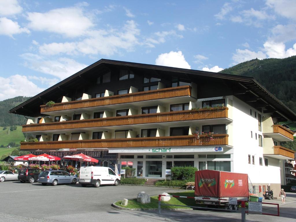 un grand bâtiment avec des voitures garées dans un parking dans l'établissement Apartmán Josef, à Kaprun