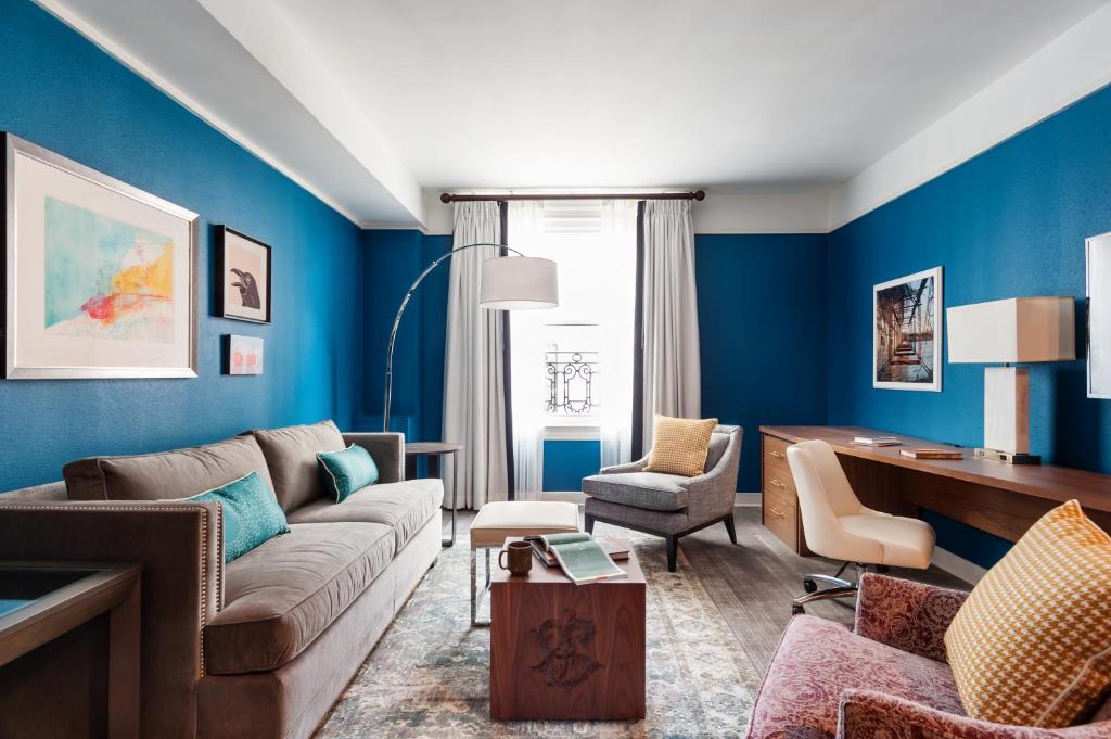 a living room with blue walls and a couch and chairs at The Commonwealth in Richmond