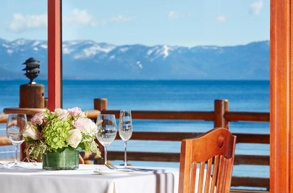 a table with wine glasses and a vase with flowers at Sunnyside Resort and Lodge in Tahoe City