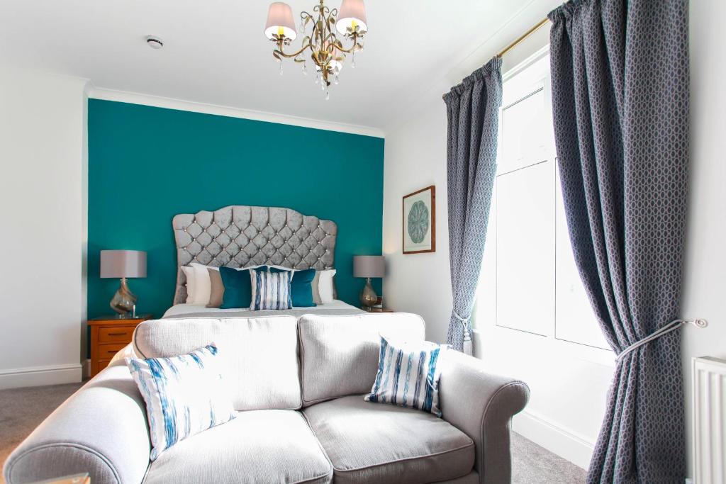 um quarto com uma cama e uma parede azul em Tyndale B&B Torquay em Torquay