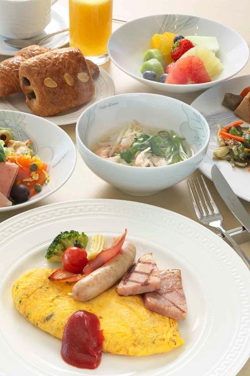 a table with plates of food and bowls of food at Osaka Marriott Miyako Hotel in Osaka