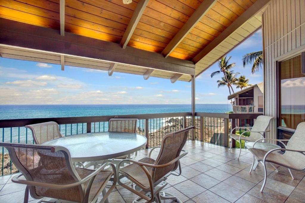 patio con mesa y sillas en el balcón en Castle Kanaloa at Kona en Kailua-Kona