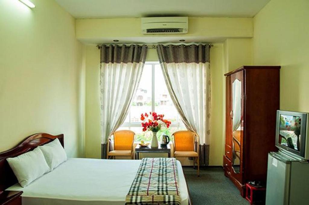 una camera d'albergo con letto e finestra di Ngoc Binh Hotel a Hue